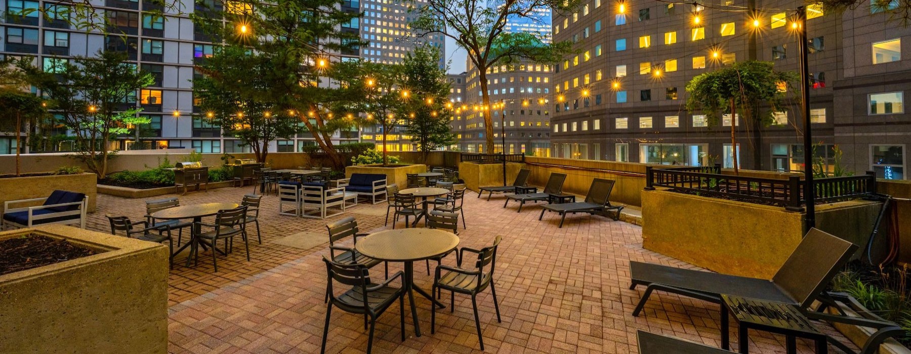 a courtyard with tables and chairs and buildings in the background